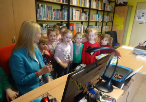 Pani Małgorzata Hofamnn prezentuje dzieciom narzędzia pracy bibliotekarza.